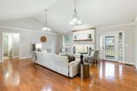 Stunning light-filled living room featuring beautiful warm hardwood floors and a spacious open layout