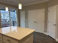 Kitchen with sliding door to a beautiful 2nd story deck  THIS PHOTO IS OF A PREVIOUSLY BUILT SIMILAR PROPERTY. THE FINISHES IN THIS UNIT MAY DIFFER.