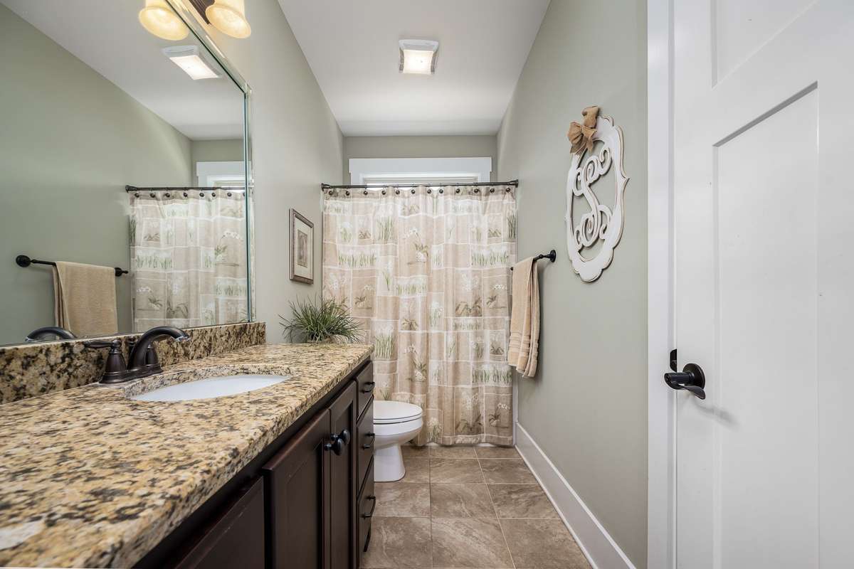 The main floor bathroom conveniently located to Bedroom 2 and the kitchen/laundry areas.