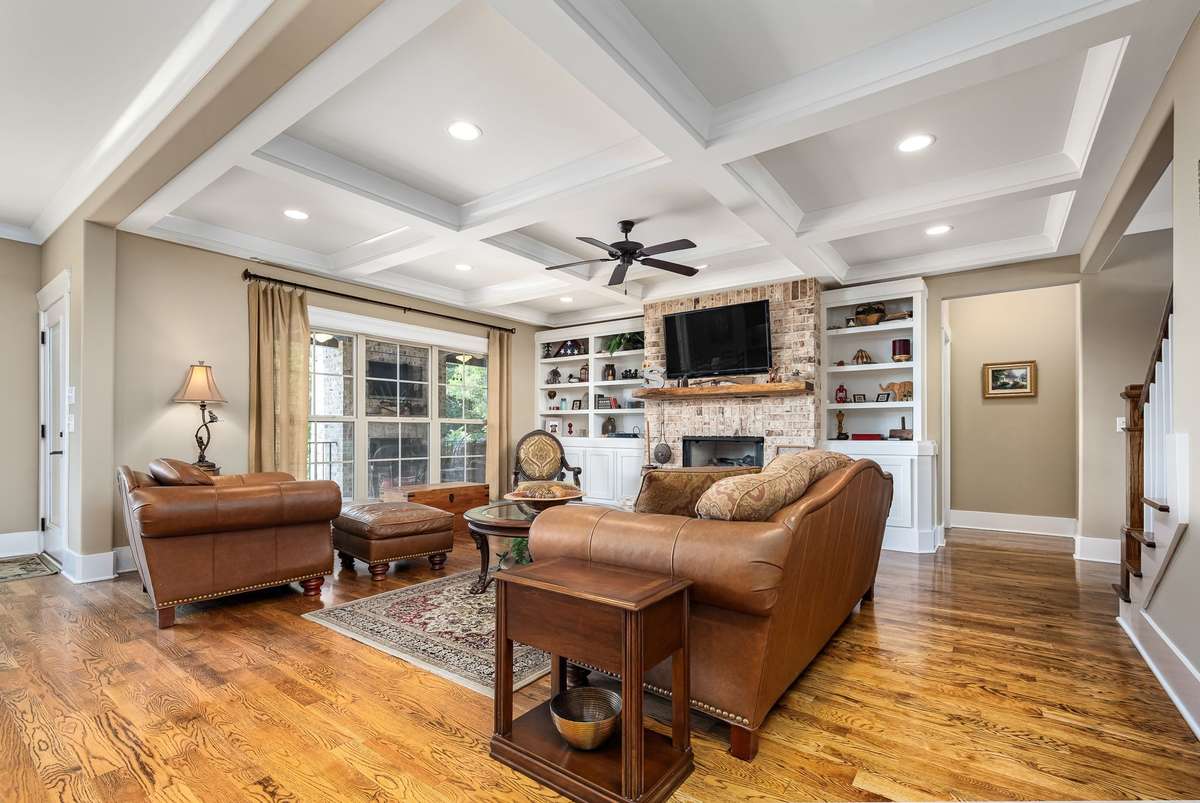 The living room features built-in bookcases & storage cabinets flanking an all brick fireplace as well as sand & finish hardwood floors.