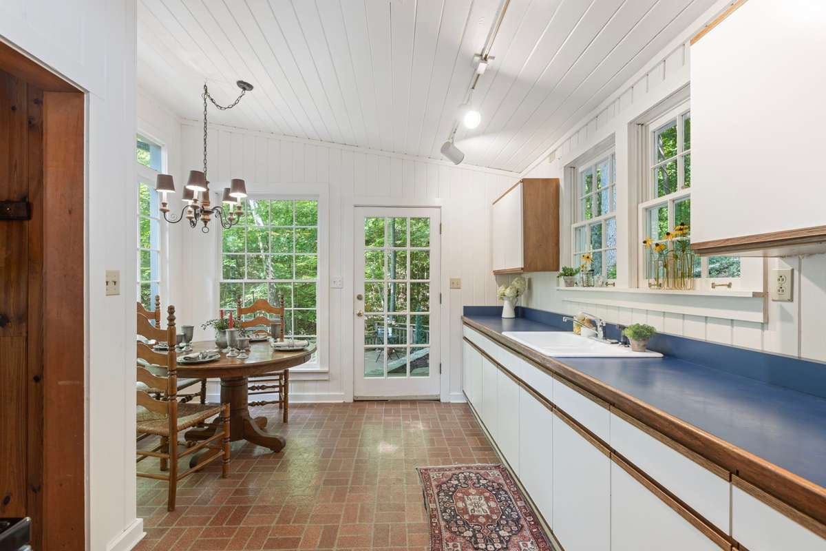 An eat-in kitchen features vaulted ceiling and sky light.