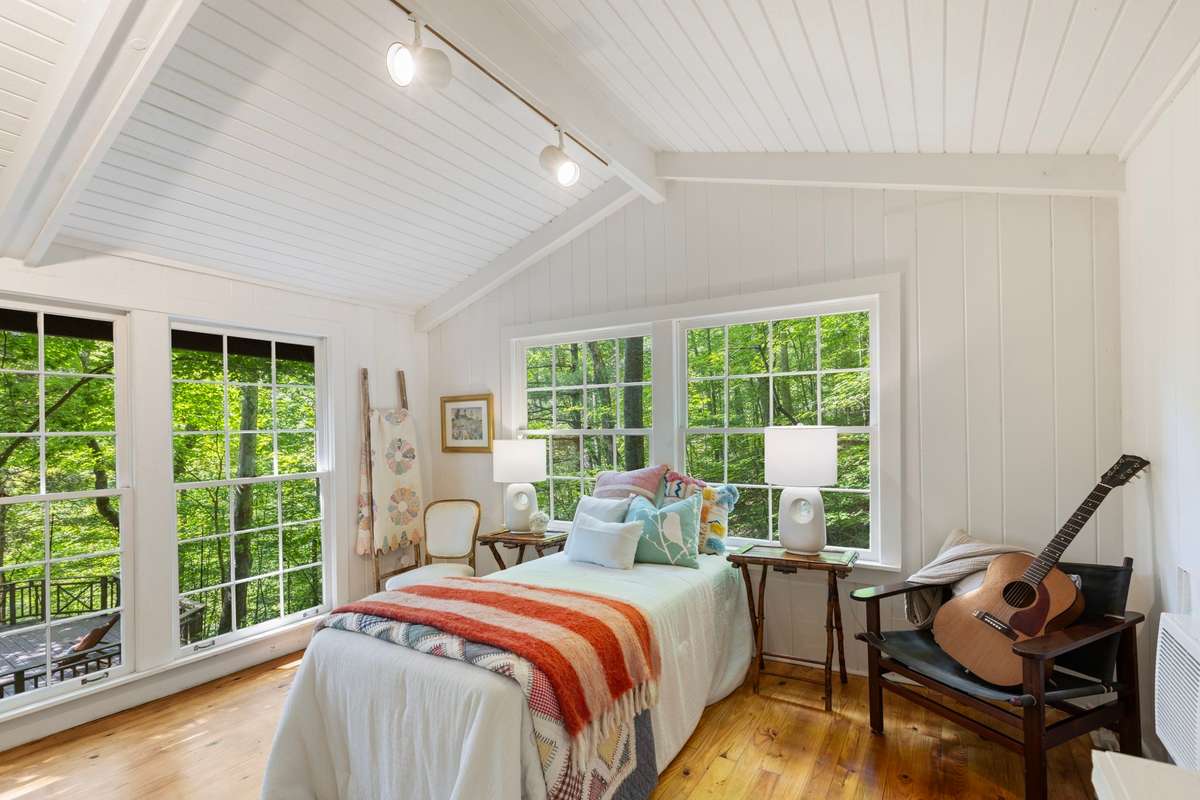 Vaulted ceiling in the studio cottage adds volume and light to the crisp white walls, perfectly framing the vivid green of the surrounding woods. You have to see it in person to truly appreciate how special this cottage is. Perfection.