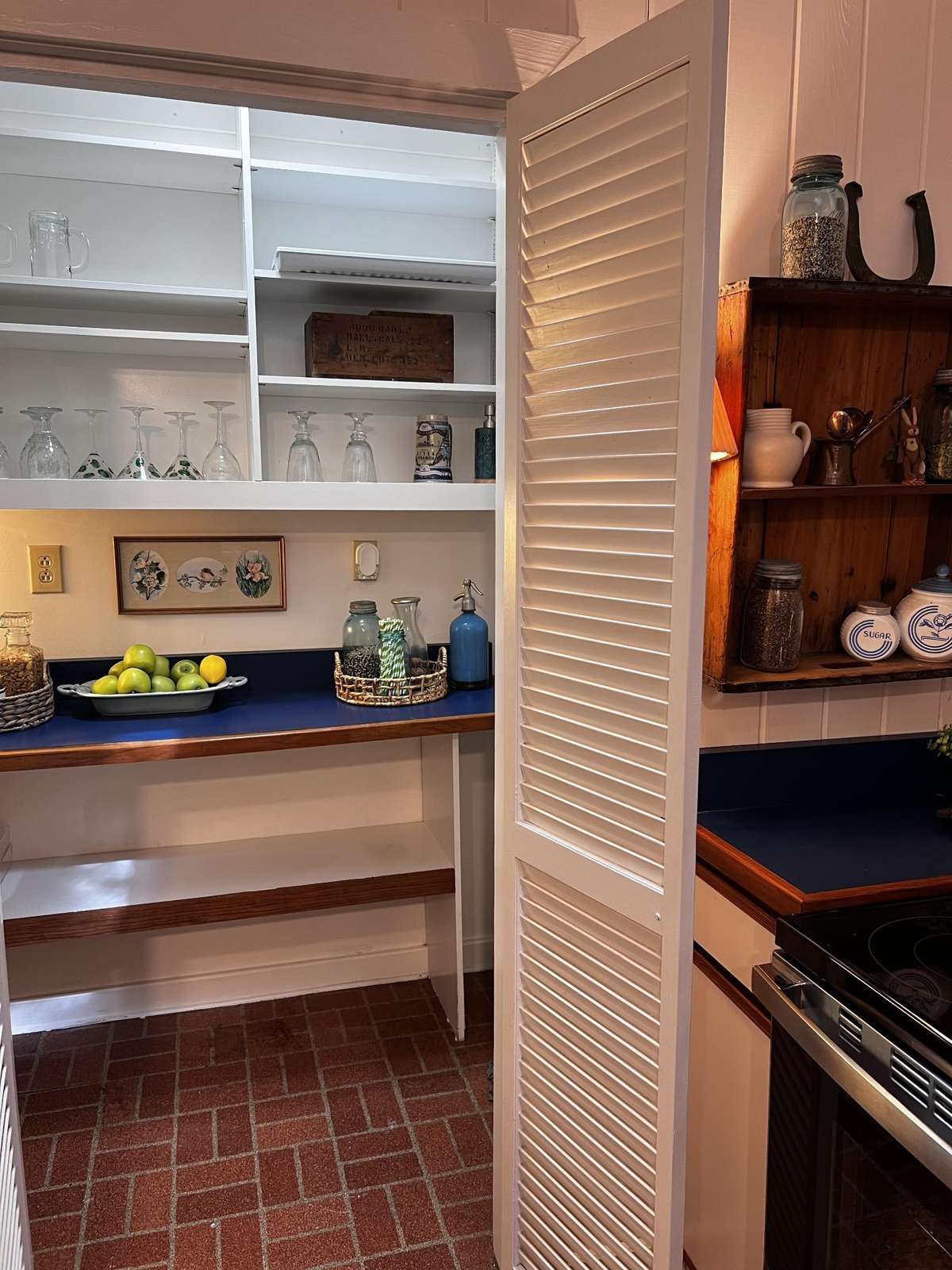 There is a wonderful and spacious walk-in pantry!  There are loads of built-in shelves to hold your supplies, canned goods & entertaining accoutrements. The countertop matches the kitchen sand is a great space to hold extra kitchen appliances!