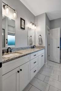 Primary bath features double vanities, a private toilet closet, a spacious walk-in shower, and a dedicated makeup vanity for added convenience.