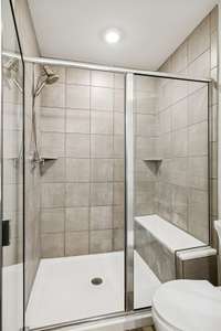 Spacious walk-in shower in the primary bathroom, featuring clean tile finishes and plenty of room for everyday comfort.