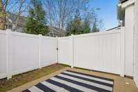 Back patio featuring a custom-sized outdoor rug that can remain with an acceptable offer, adding comfort and style to this private, fenced outdoor space.