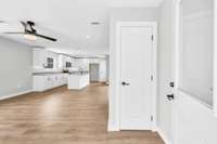Walking in to the main living room, showing the coat closet and kitchen.