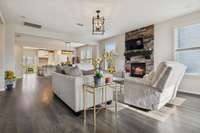 Open concept living room with stacked stone fireplace, modern farmhouse light fixture, & two windows providing great natural lighting. 549 Montrose Dr. Mt. Juliet, TN 37122