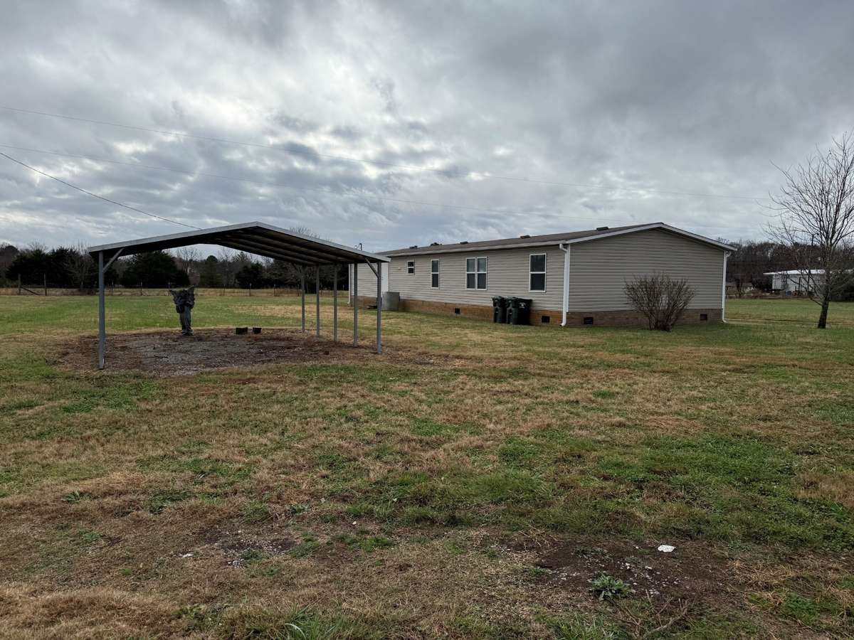 Side yard- detached carport, back of house, vinyl siding, new gutters, composition shingle roof