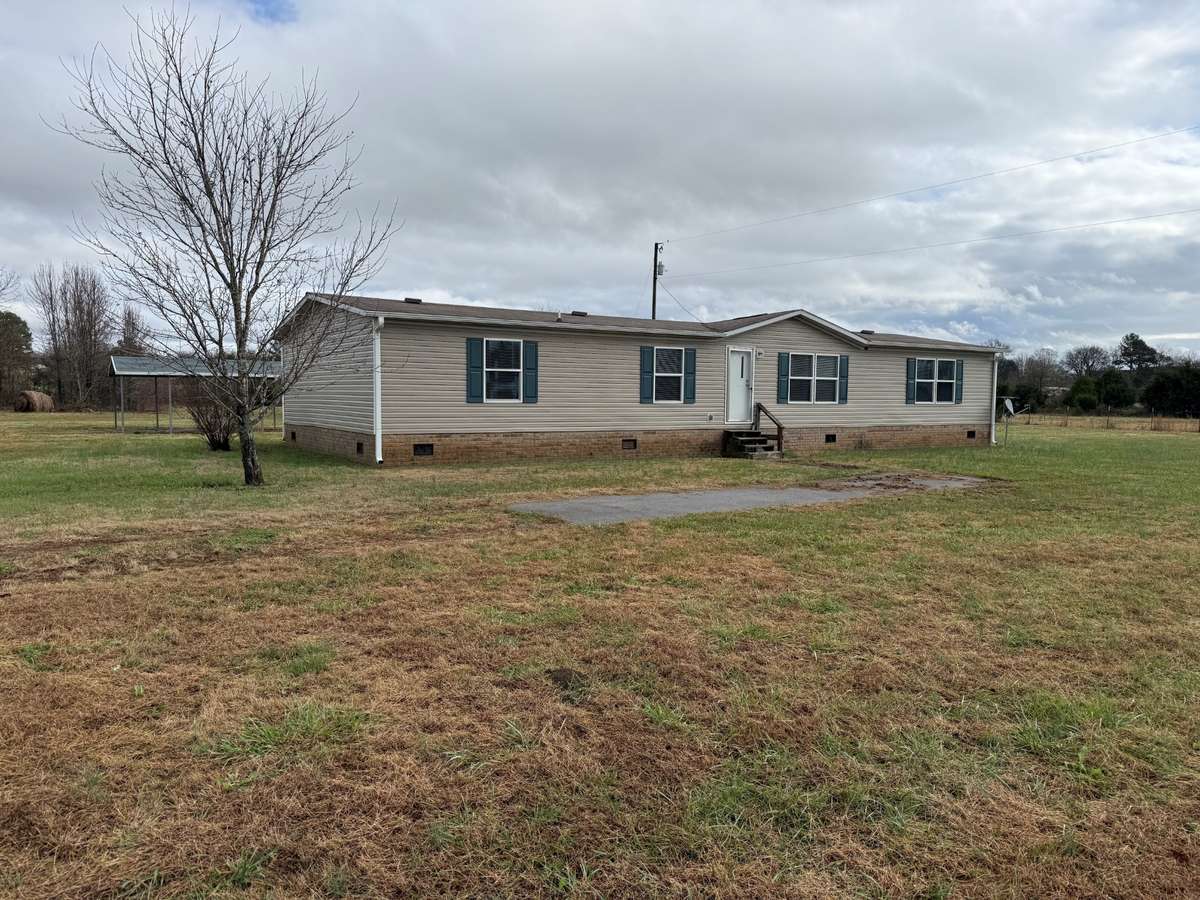 Front of house- 2018 Southern Energy Mobile Home - vinyl siding on a permanent foundation, composition shingle roof, new gutters, gravel driveway