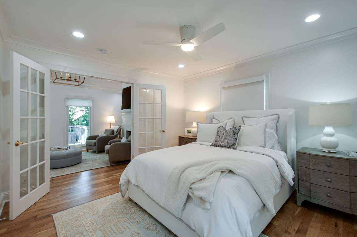 The main floor bedroom has recessed puck lighting, a ceiling fan/light and great natural light. The room has a set of French doors that open up to the living room.