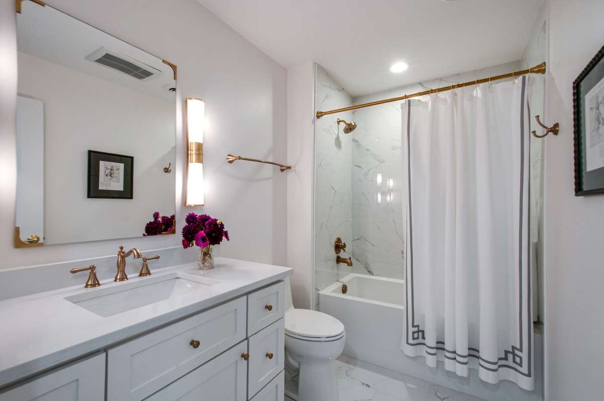 The totally renovated upper level bathroom has a stylish mirror, lovely fixtures and pretty finishes throughout.