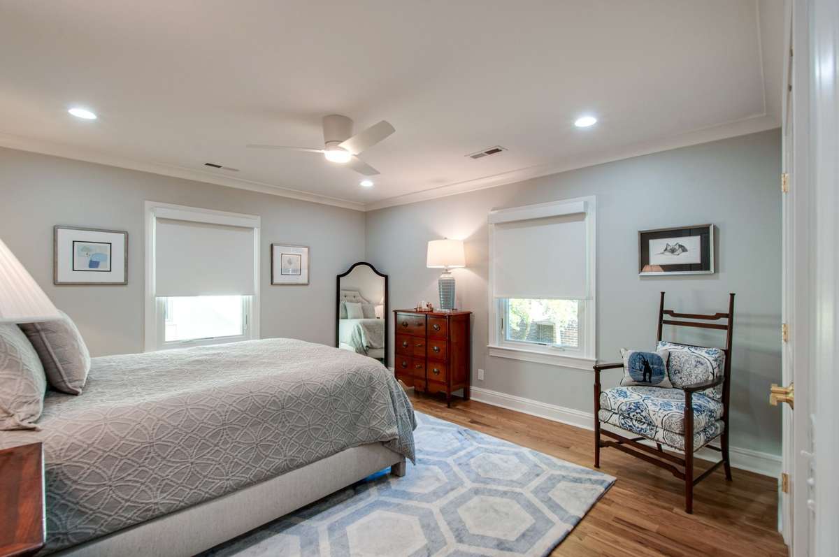 Another view of the primary bedroom showing the windows that are covered with custom blackout shades.