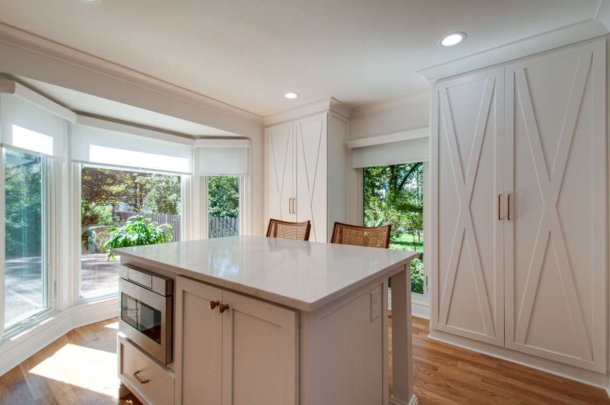 The sun-kissed breakfast room has custom built-ins for extra storage with the most beautiful doors!