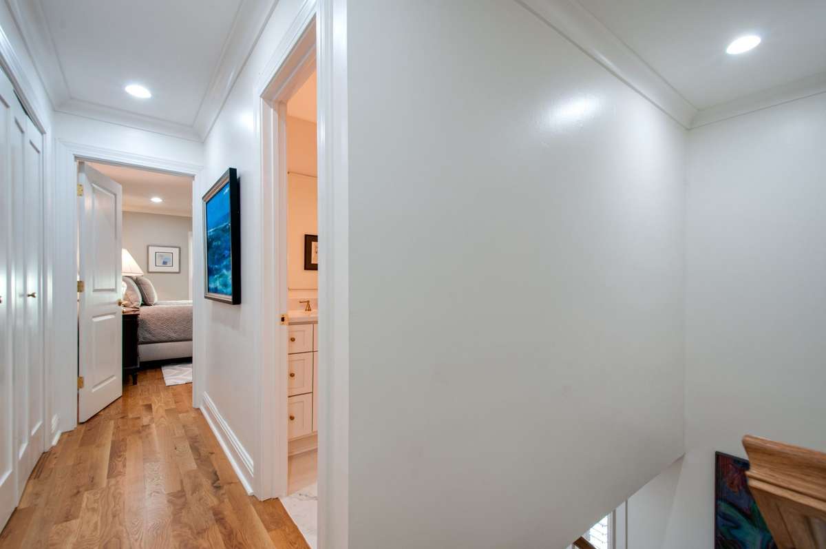 Upstairs there is a hallway connecting the two upper bedrooms with a bathroom on one side and storage closets on the other.