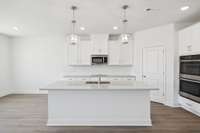 ***Photo from a previously built Hampstead home - options may vary***

Enjoy cooking in your beautiful gourmet kitchen that features bright white cabinetry, quartz countertops and a herringbone backsplash!