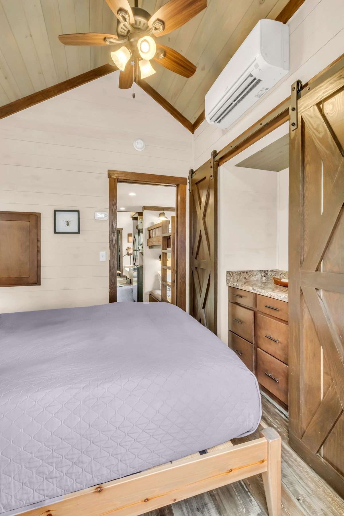 A built-in dresser is flanked by 2 closets on each side with sliding barn doors for the most optimal use of the space. The bedroom has a pocket door into the hallway so there are no battles of doors anywhere in this house!