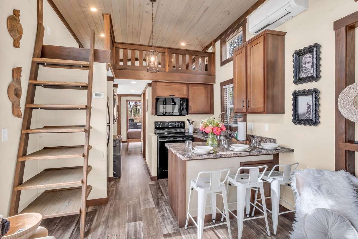 The living room opens up to the kitchen and the ladder on the left leads to the loft and offers additional space for storage or display