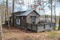 Another view of the house from the backyard showing the deck off the primary bedroom