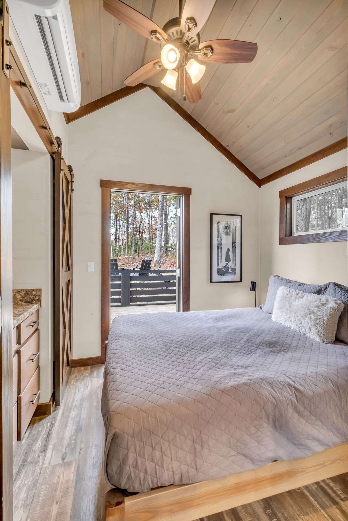 The bedroom has a mini split HVAC and a ceiling fan. Notice the wood detail on the ceiling!