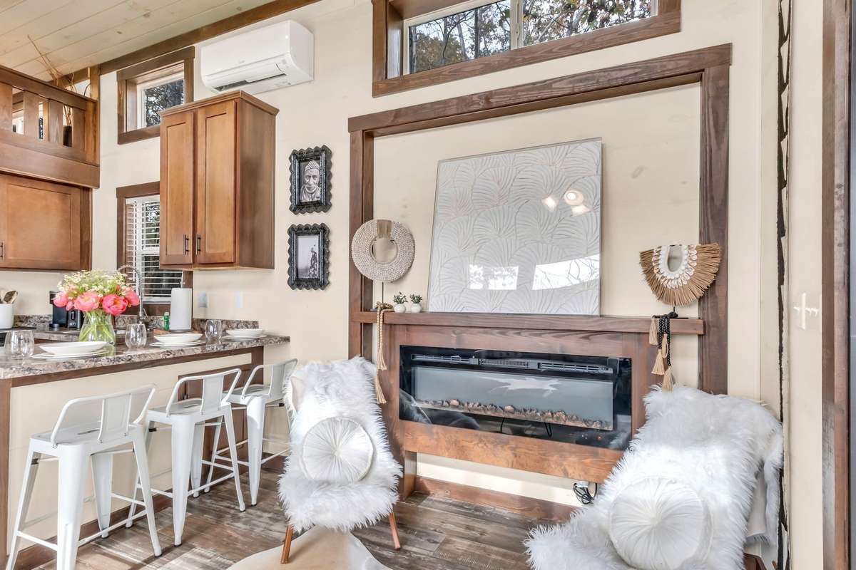 The living room has an electric fireplace and space to hang your TV above it (behind the art piece currently sitting on the mantel).