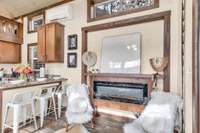 The living room has an electric fireplace and space to hang your TV above it (behind the art piece currently sitting on the mantel).