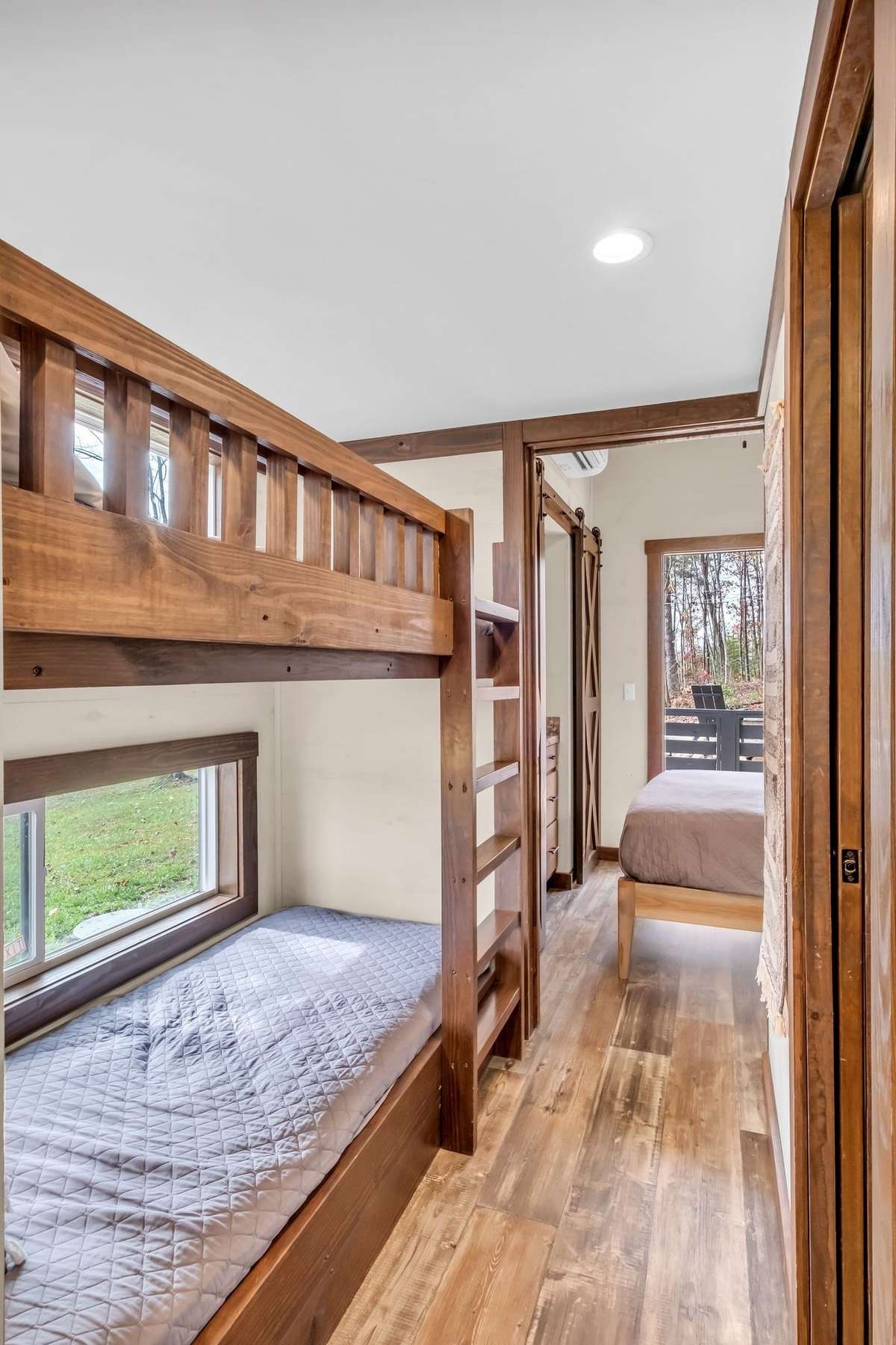Built-in bunk beds in the hallway to the primary bedroom. Each bunk has its own sliding window, reading light and electric outlet.
