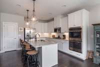 Beautiful large island with seating for a few to enjoy when entertaining. Stainless Steel Double ovens, cooktop, microwave and dishwasher.