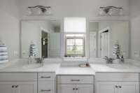 Beautiful white cabinetry vanities with double sinks and mirrors.