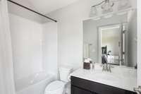 Upstairs full bathroom with tiled floor, tiled shower / tub combo.