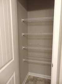 The primary bedroom comes with a modern shower, two sinks, and an elongated toilet, as well as a linen closet