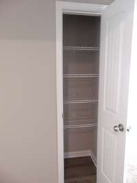 The second bathroom has a elongated toilet, a bath and shower combo, and a modern sink. There is also a linen closet for extra space.