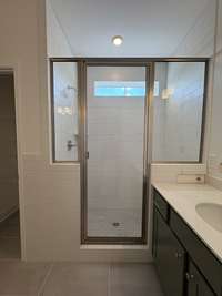 Tiled shower with Bench in Master Bath.  Tile floors.  Split vanity with quartz counters