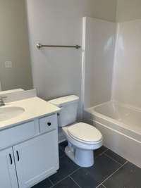 hall bath with tile floors, quartz counters and under mount sink