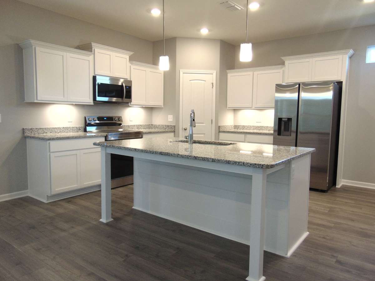 The kitchen where you can cook all your specialty dishes with love. This kitchen has under cabinet lights, included steel appliances, as well as a modern and large island and sink.