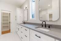 the master bathroom features double vanities and a chic tile backsplash