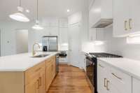 Kitchen features a custom build hood vent and gas range.