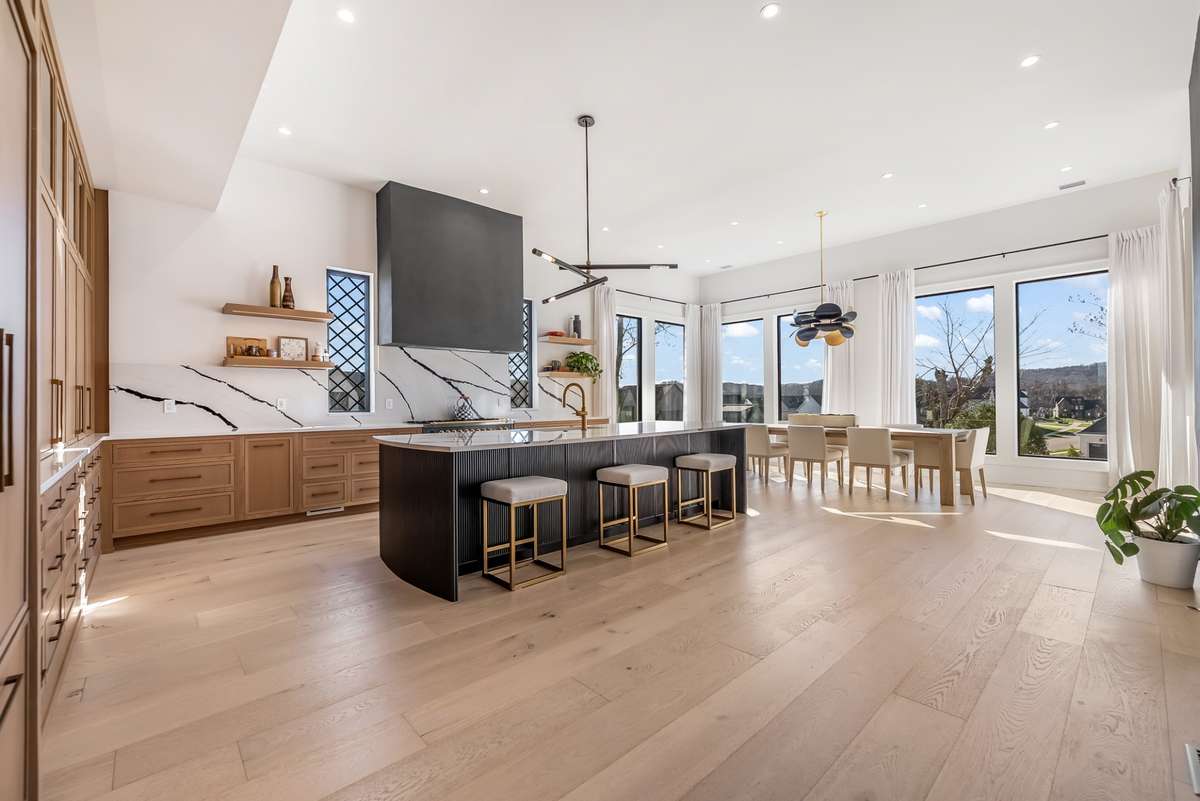 Chef's kitchen with custom cabinetry, quartz countertops and backsplash, hand-made italian range, and Jennair refrigerator.