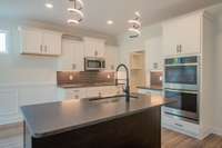 Large Kitchen with Under Cabinet Lighting, Granite Countertops, Island with Bar Top, Stainless Steel Appliances including a Double Oven, Lots of Cabinet & Counter Space and a Walk-in Pantry!