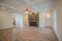 Large Great Room with a Floor to Ceiling Stone Fireplace, Recessed Lighting, Coffered Ceiling and Shiplap Accent on the Ceiling!