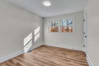 This bedroom looks out over the back yard.  Updated like the rest of the house, it would be a great guest room or kids room.