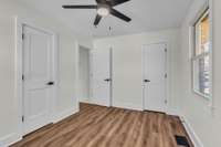 Primary bedroom with new doors/hardware, flooring, paint, ceiling fan, 2 closets and full remodeled bathroom.