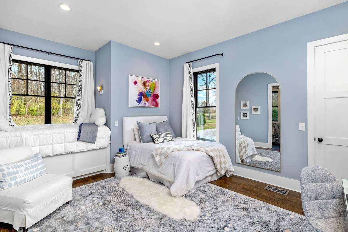 Bedroom 3 is an incredible space with a window bed, huge windows, and lots of of built-in cabinets. The door on the right is a large, walk-in closet with built-ins and hanging area.