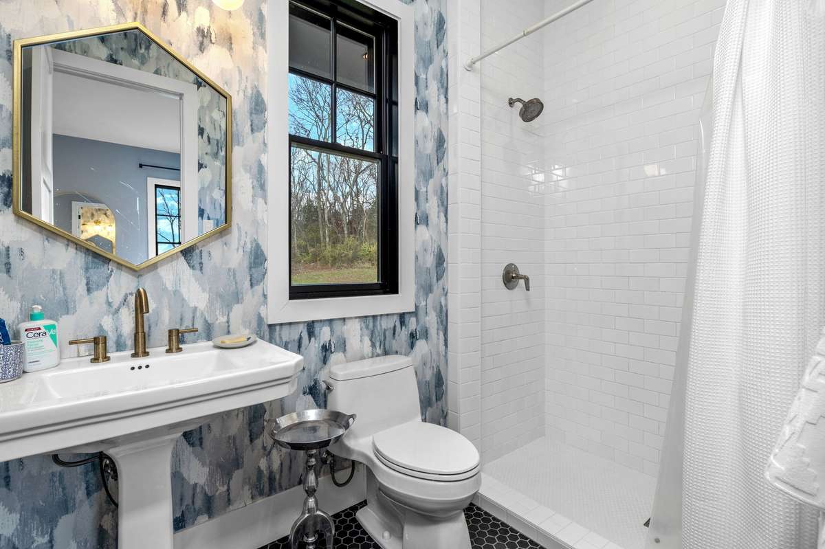 This ensuite bath is just adorable with built-in shelving behind the entry door and lots of storage.