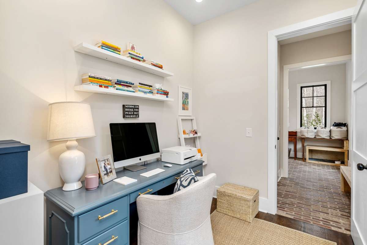 Step down the hallway to our office. You truly get inspired sitting here surrounded by windows. In the distance you see the laundry area with boot bench and water-proof flooring. Come in the back door and take off your riding gear and climb into bed!
