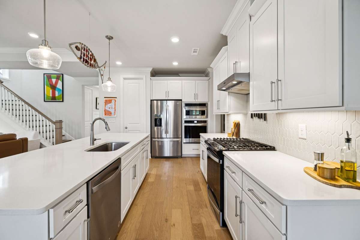 This high functioning work space includes a hard to find commercial style gas range & hood,  plus an additional wall oven, convection microwave and lots of counter space.