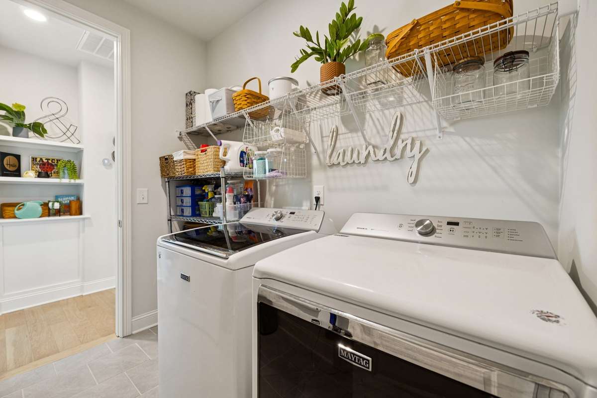 Conveniently located steps away from the primary bedroom, is the laundry room.