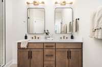 Primary bathroom includes double vanities and separate water closet.  *Photos are of a similar floorplan with differing finishes.*
