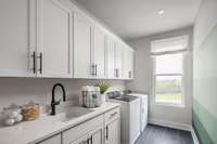 Laundry room with lots of storage, sink, and counter space. *Photos are of a similar floorplan with differing finishes*