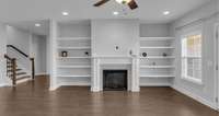 View of your large living room with a cozy fireplace, built in shelves, and a perfect place for your TV above the fireplace
